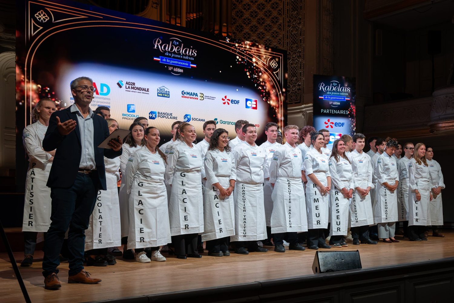 Les lauréats de la 14ᵉ édition des Rabelais des Jeunes Talents de la Gastronomie sur scène à Paris, devant l'écran des partenaires où figure BIOCOLD PROCESS